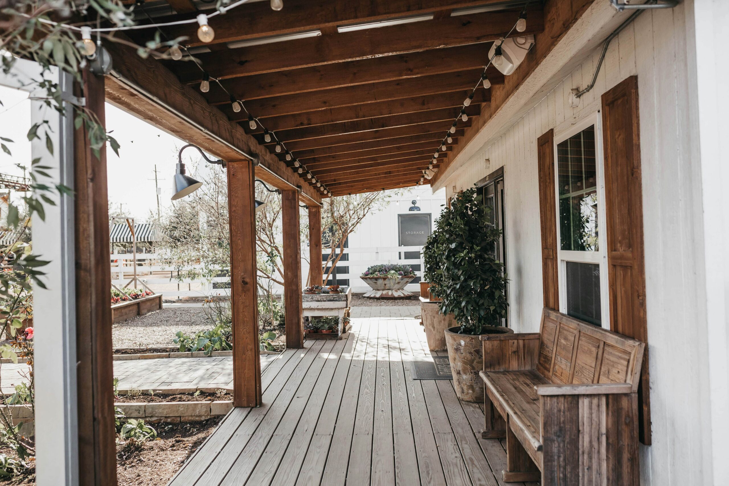 White wood farmhouse porch with rustic bench and string lights – Amazon farmhouse decor under $100